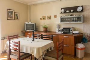 a dining room with a table and a tv at Apartments Miljan Popovic in Cavtat