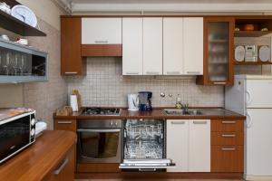a kitchen with wooden cabinets and white appliances at Apartments Miljan Popovic in Cavtat