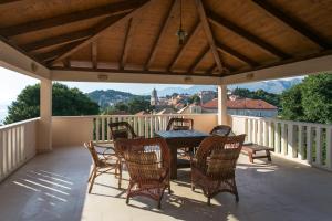 a patio with a table and chairs on a deck at Apartments Miljan Popovic in Cavtat