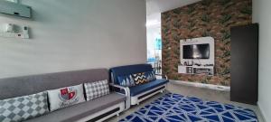 a living room with a couch and a tv at Rest n Splash by Home Stay Cikgu D'Inapan Kijang in Alor Setar