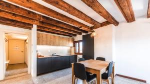 uma cozinha e sala de jantar com uma mesa de madeira e cadeiras em Residenza Al Mercato Grand Canal em Veneza