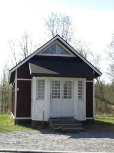 a small red and white shed with a door at Villa Elba in Kokkola