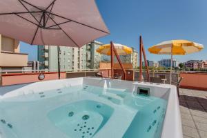 wanna z hydromasażem na dachu budynku z parasolami w obiekcie Hotel Joli w Cesenatico