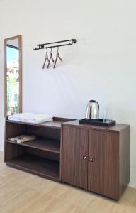 a wooden cabinet with a mirror and a shelf at Phorpun Resort 