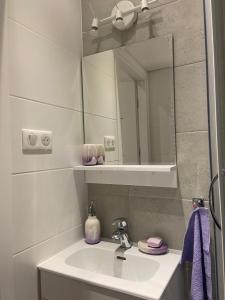 a bathroom with a sink and a mirror at Urocze mieszkanko in Krosno