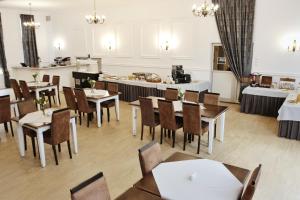 un restaurante con mesas y sillas y una cocina en Żbik, en Spała