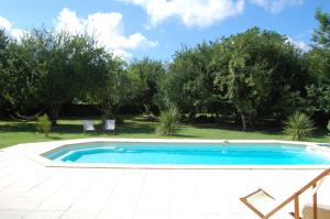 a swimming pool in a yard with trees at Château Le Souley in Vertheuil-en-Médoc