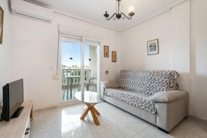 a living room with a couch and a tv at HE DORIS in Orihuela Costa