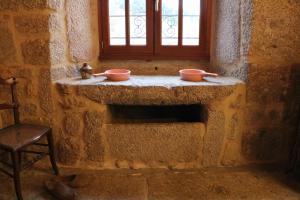 Habitación de piedra con 2 cuencos en una pared de piedra en Le petit château du Villard, 