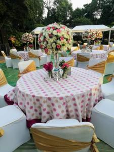 una mesa con un mantel rosa y blanco con flores. en Aaron Residency en Nueva Delhi