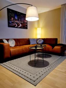 a living room with a brown couch and a table at Moderne Ferienwohnung im Herzen von Schleswig in Schleswig