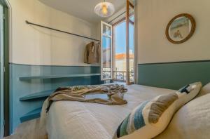 a bedroom with a large bed with a window at Papagayo, appartement halles et côte des basques in Biarritz