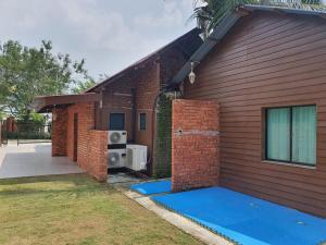 une maison en briques avec un tapis bleu devant elle dans l'établissement Bali Paradise Cottage, à Kampung Tumbuk Pantai