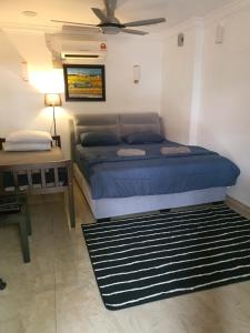 - une chambre avec un lit et une table avec un ventilateur dans l'établissement Bali Paradise Cottage, à Kampung Tumbuk Pantai