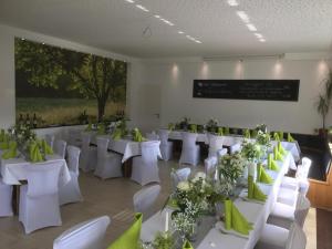 une salle de banquet avec des tables blanches et des chaises blanches dans l'établissement Gasthof Kirschtraum, à Sontra