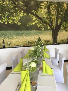 einen langen Tisch mit gelben und grünen Kissen in der Unterkunft Gasthof Kirschtraum in Sontra