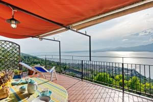 d'un balcon avec une table et des chaises et une vue sur l'eau. dans l'établissement Terrazza Torri del Benaco, à Torri del Benaco