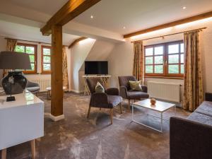 salon z kanapą, krzesłami i telewizorem w obiekcie Fährhauslodges Natur in Sicht w mieście Norden