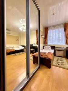 キーロフにあるHotel Preobrazhenskayaのベッドルーム1室(ベッド2台、大きな鏡付)