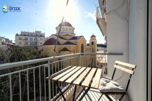 a balcony with a wooden bench and a church at The Spiritual Athens Apartment in Athens