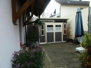 um pátio com uma porta e um guarda-chuva ao lado de uma casa em Pension/FeWo E. Tschernach em Treuchtlingen