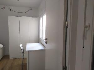 a white room with a desk and a window at Feel Welcome Barcelona Smart flat in Cornellà de Llobregat