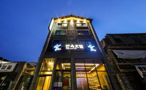 ein hohes Gebäude mit einer Uhr darüber in der Unterkunft Jeonju Hanok Hotel Kung in Jeonju