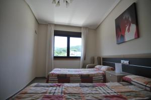 Posteľ alebo postele v izbe v ubytovaní Apartamentos Turisticos Vilagarcía- Rio Ulla + 30 fotografií
