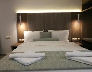 a bedroom with a large bed with towels on it at 4- you Family in Metamorfosi