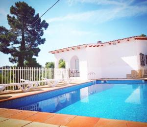 een zwembad voor een wit huis bij Villa Mas Blau in Lloret de Mar