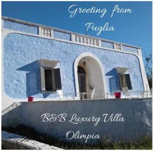 un bâtiment bleu avec les mots qui alimentent le russia dans l'établissement B&B Luxury Villa Olimpia Home Restaurant, à Selva di Fasano