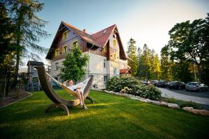 een vrouw in een hangmat voor een huis bij Stacja Szklarska Poręba - cisza i komfort in Szklarska Poręba