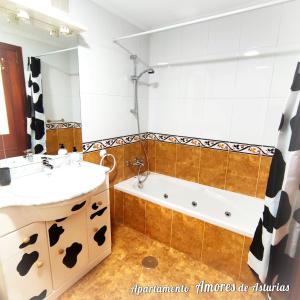 a bathroom with a sink and a bath tub at AMORES DE ASTURIAS in Piedras Blancas