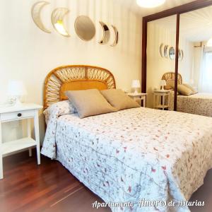 a bedroom with a bed and a mirror on the wall at AMORES DE ASTURIAS in Piedras Blancas