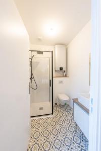 een badkamer met een douche en een toilet bij L'elegant - Appart'Hotel Le Gatsby in Saint-Quentin