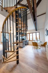 een wenteltrap in een kamer met een tafel en stoelen bij L'elegant - Appart'Hotel Le Gatsby in Saint-Quentin