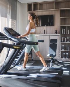 a woman walking on a treadmill in a gym at Hotel AMI Budva Petrovac in Petrovac na Moru