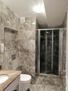 y baño con ducha, aseo y lavamanos. en Opatija Hotel, en Estambul