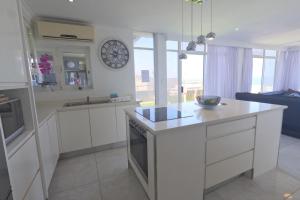 een keuken met witte kasten en een aanrecht bij 41 Licorna Beach in Durban