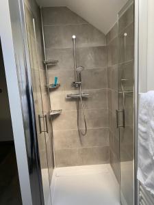 eine Dusche mit Glastür im Badezimmer in der Unterkunft Résidence avec un T3 un T2 et un STUDIO en Centre Ville d Argeles-Gazost in Argelès-Gazost