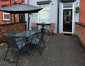 een tafel en stoelen met een parasol op een patio bij king Bed Premium luxury suite + Free Parking + Free Fast WiFi in Morley