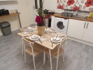 a wooden table with chairs and a washing machine at king Bed Premium luxury suite + Free Parking + Free Fast WiFi in Morley +16 photos