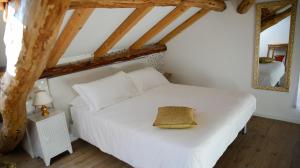 a bedroom with a white bed and a mirror at Combo Rooms in Garna dʼAlpago