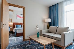 a hotel room with a couch and a bed at Ramada by Wyndham Astana in Astana