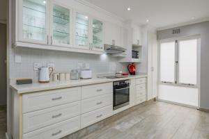 Una cocina blanca con gabinetes y electrodomésticos blancos. en San Lameer Villa 2537 - 4 Bedroom Superior - 8 pax - San Lameer Rental Agency, en Southbroom