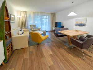 ein Wohnzimmer mit Tisch und Stühlen in der Unterkunft Dünenpark Binz - WG 73 "Strandläufer" mit Terrasse in Binz