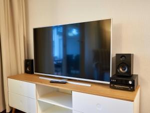 einen Flachbild-TV auf einer Kommode mit Lautsprechern in der Unterkunft Dünenpark Binz - WG 73 "Strandläufer" mit Terrasse in Binz + 17 Fotos