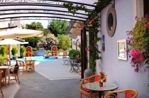 un patio con tavoli, sedie e piscina di Arciduca Grand Hotel a Città di Lipari