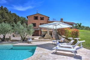 une piscine avec des chaises et un parasol ainsi qu'une maison dans l'établissement Villa San Lorenzo - Hilltop Villa With Private Pool, Jacuzzi & AirCO, à Montone