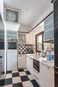 a kitchen with white cabinets and a checkered floor at Panorama Loft in Chalkida